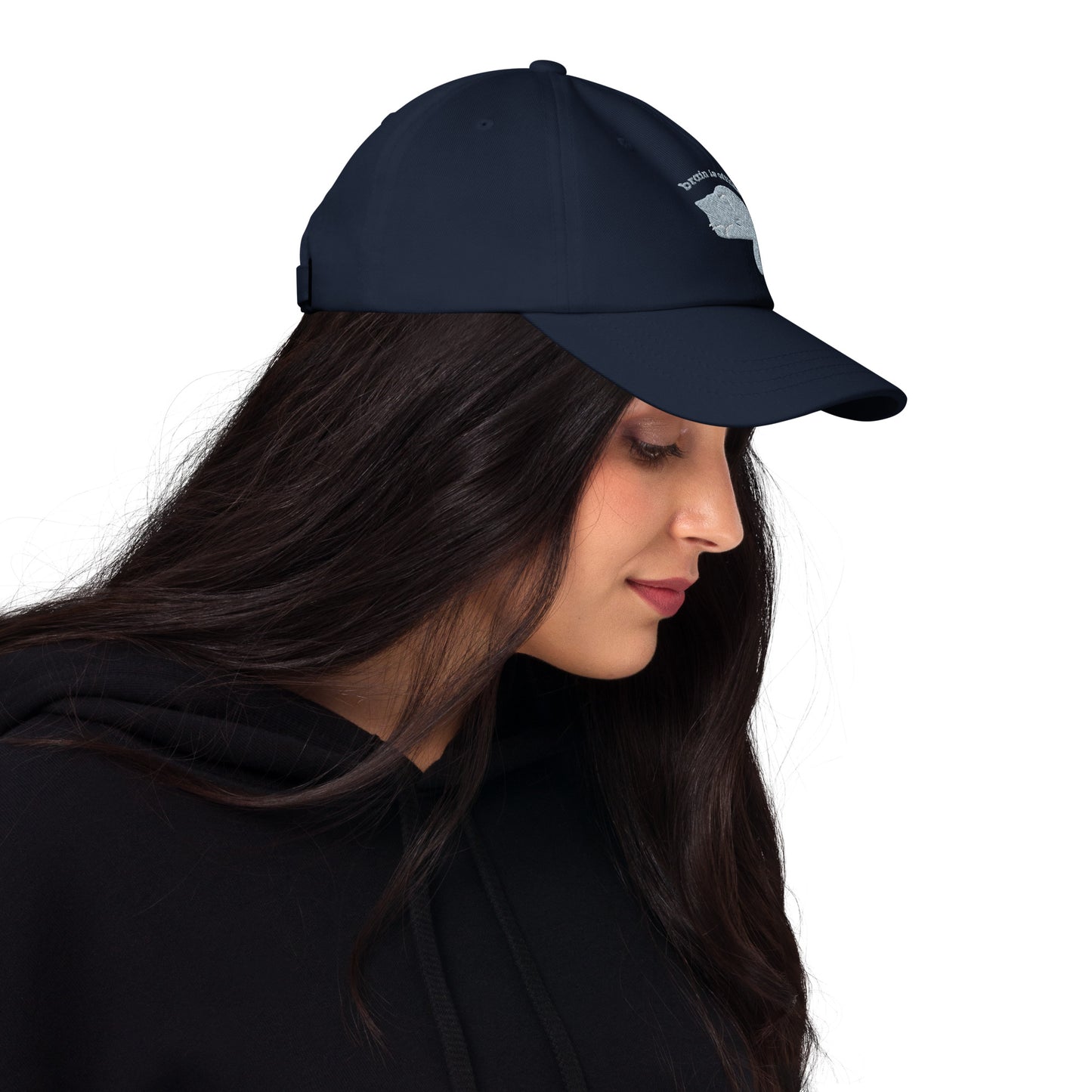 Woman wearing a navy cap with a design of a cat hiding its face and the words 'Brain is Offline'.
