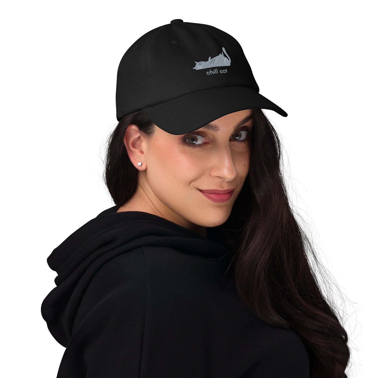Woman wearing a black cap with a design of a cat lying down and the words "Chill Cat".