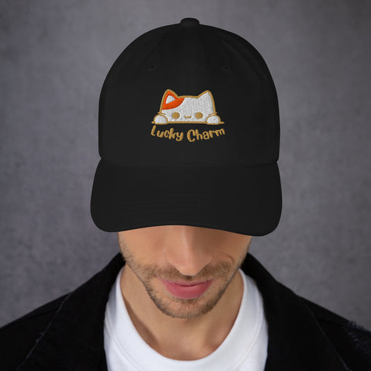 Man wearing a black cap with a design of a cat's face and the words 'Lucky Charm'.