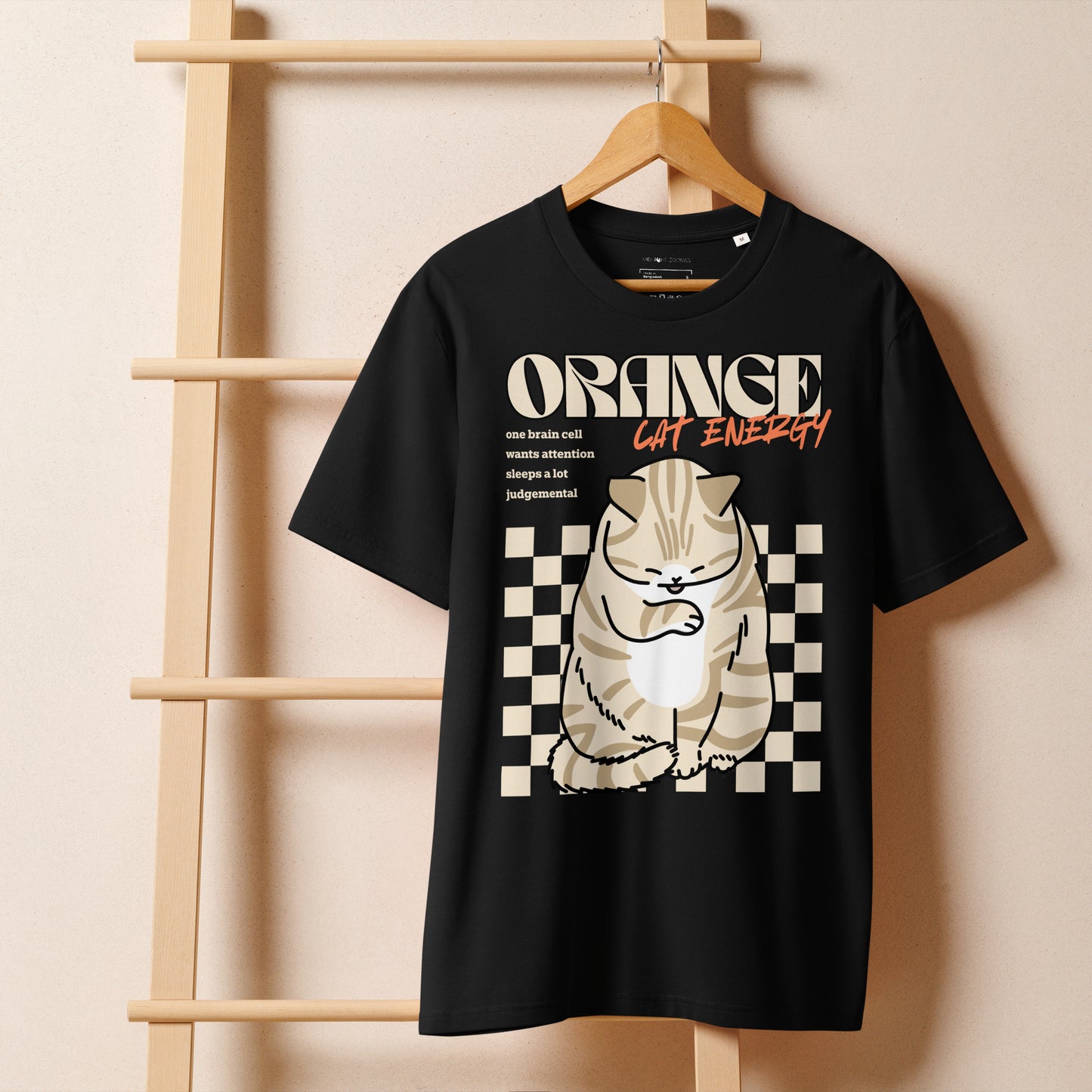 A black Orange Cat Energy T-Shirt from Midnight Zoomies on a hanger.