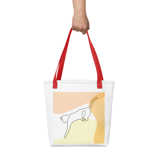 Front View of a tote bag with a design of a cat outline playing. Red Handle.