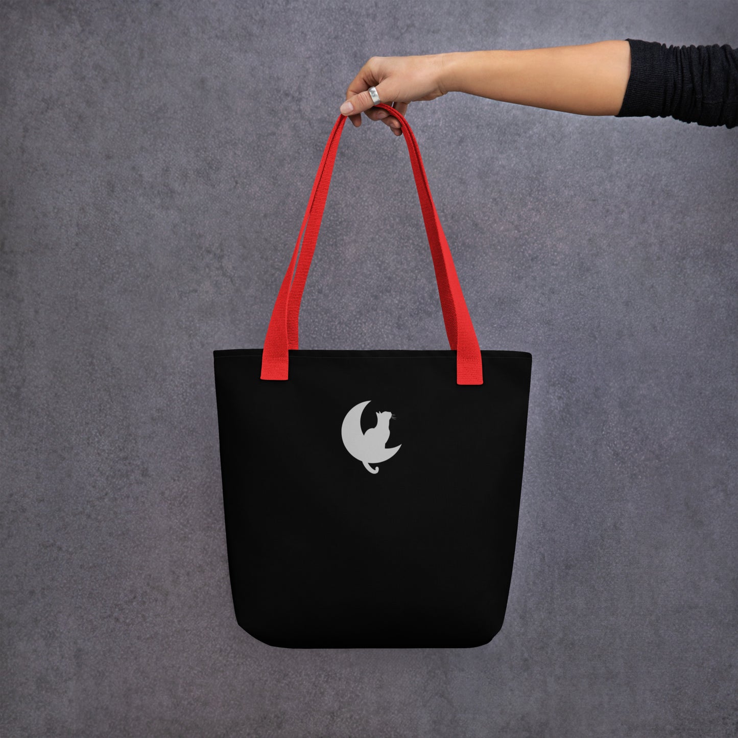 Back View of a black tote bag with a design of two stargazing cats. Red Handle.
