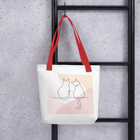 Front View of a tote bag with a design of two cat outlines. Red Handle.