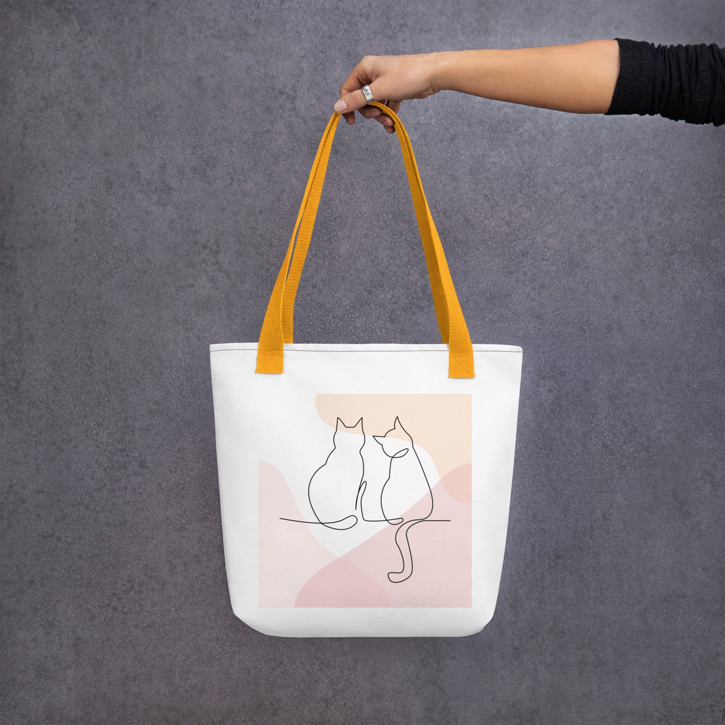 Front View of a tote bag with a design of two cat outlines. Yellow Handle.