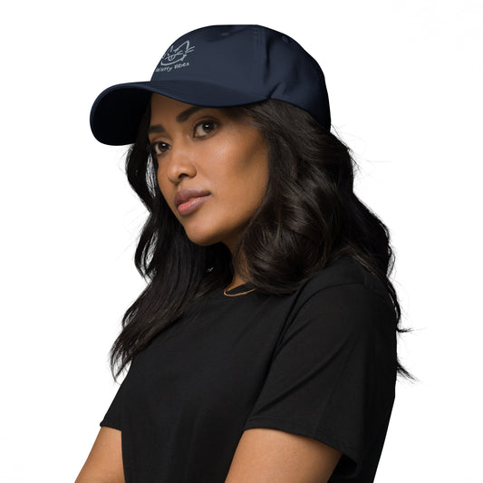Woman wearing a navy cap with a design of a cat's face and the words 'Bad Kitty Vibes'.