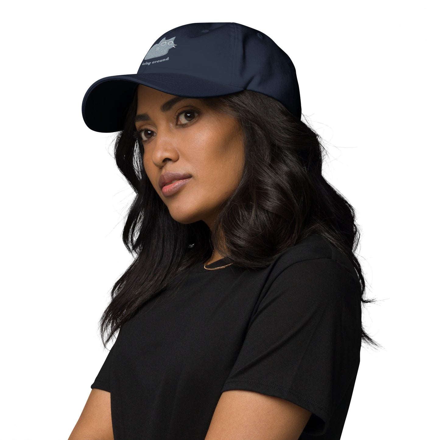 Woman wearing a navy cap with a design of a cat relaxing and the words "Loafing Around".