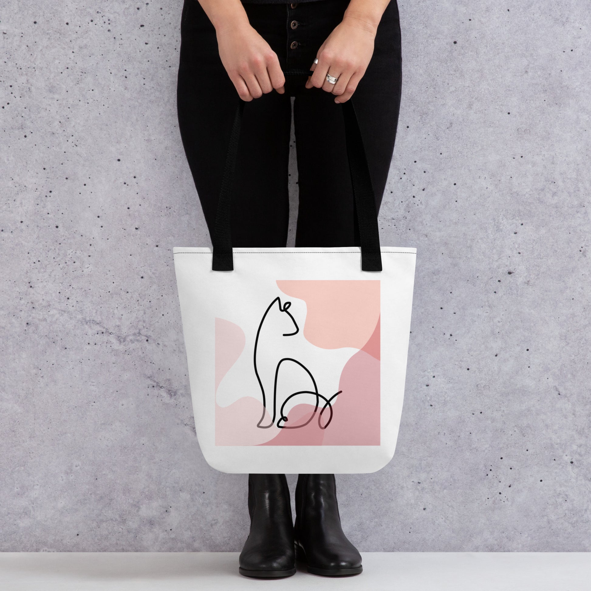 Front View of a tote bag with a design of a sitting cat outline. Black Handle.